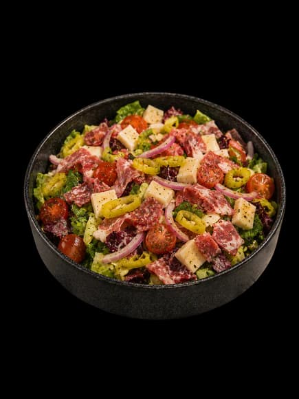 Chopped Italian salad with cured meats, provolone, tomatoes, and pepperoncini