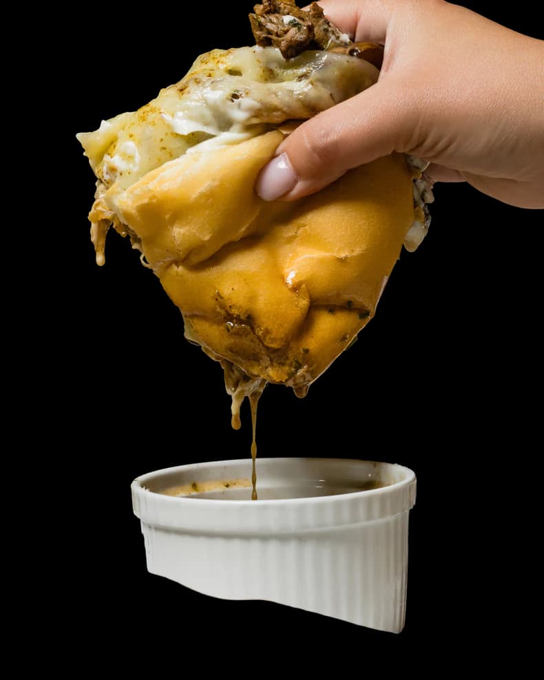 Ribeye sandwich served with a cup of au jus