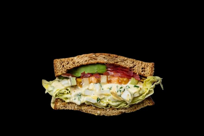 Egg salad sandwich with bacon, tomato, and butter leaf lettuce