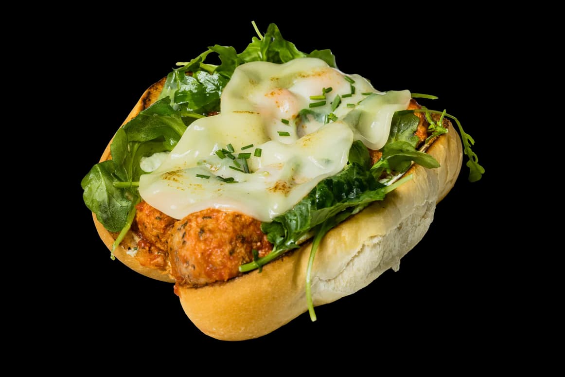 Chicken meatball pesto sandwich with melted mozzarella and greens